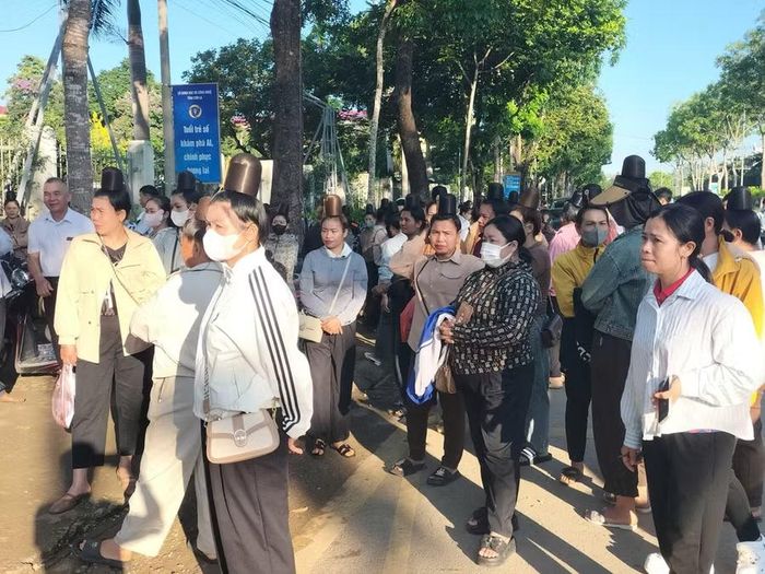 Phụ huynh đứng trước cổng trường chờ con thi vào lớp 10.