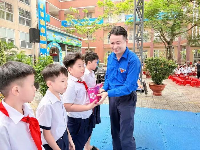 Anh Lê Tuấn Anh - Phó bí thư Thành đoàn, Chủ tịch Hội Liên hiệp thanh niên Việt Nam TPHCM trao quà cho học sinh.
