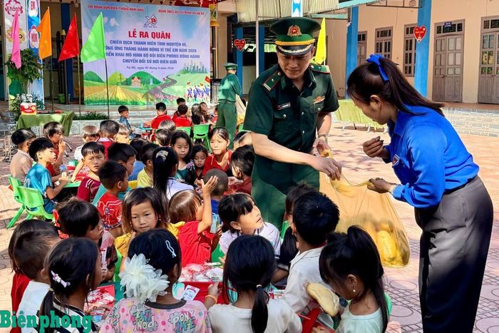Cán bộ Đồn Biên phòng Nậm Nhừ và đại diện Đoàn Thanh niên xã Nà Hỳ chăm lo bữa ăn cho các em học sinh. Ảnh: Mùa Tùng
