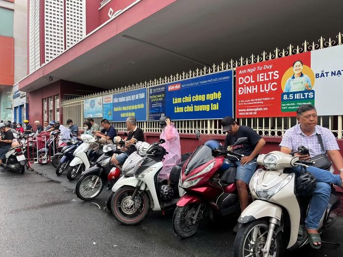 Nhiều phụ huynh vẫn kiên nhẫn đứng chờ con dù trời mưa lớn.