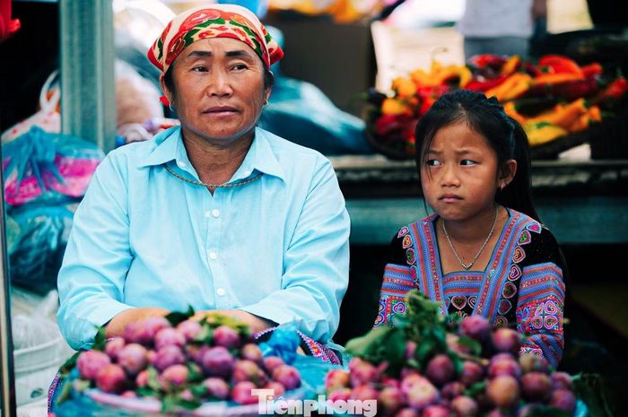 Em nhỏ ngồi bán hàng trong phiên chợ cùng mẹ, cùng bà.