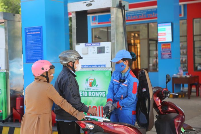 Nhân viên cửa hàng xăng dầu PVOIL trao đổi, tư vấn với khách hàng.