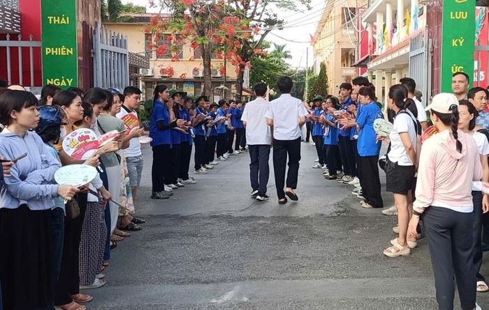 Các thí sinh nhận sự quan tâm cổ vũ của phụ huynh và tình nguyện viên tại điểm thi trường THPT Thái Phiên. Ảnh: Xuân Hải
