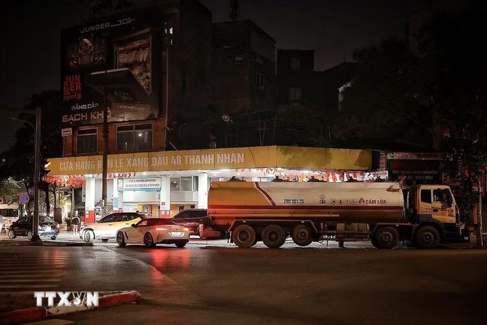Tối 31/5, tại cửa hàng bán lẻ xăng dầu 48 Thanh Nhàn, nhiều phương tiện vẫn tranh thủ vào đổ xăng RON95 trước thời điểm chuyển đổi sang xăng E10. Theo chia sẻ của quản lý cửa hàng, đúng 0h ngày 1/6/2026, đơn vị sẽ bắt đầu chuyển sang bán xăng E10; xe bồn đã túc trực chờ nhập nhiên liệu mới sau khi bán nốt lượng xăng còn lại trong ngày. (Ảnh: Phạm Tuấn Anh/TTXVN)