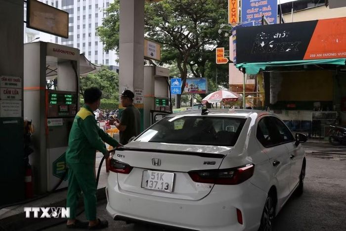 Người dân đổ xăng tại cây xăng góc đường 259 An Dương Vương, thuộc phường Chợ Lớn, Thành phố Hồ Chí Minh. (Ảnh: Thanh Vũ/TTXVN)