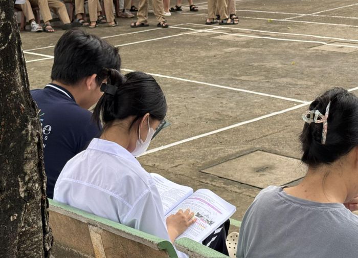 Các thí sinh tranh thủ ôn bài trước khi vào phòng thi tại điểm thi Trường THCS Hoa Lư.