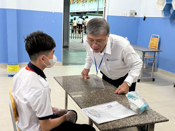 Thầy Hiếu hỏi thăm thí sinh tại điểm thi Trường THCS Đoàn Thị Điểm.