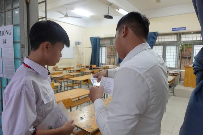 Giáo viên đối chiếu thông tin dự thi, hướng dẫn thí sinh ổn định trước giờ làm bài môn Ngữ văn tại điểm thi trường THCS Trường Thọ, phường Thủ Đức.