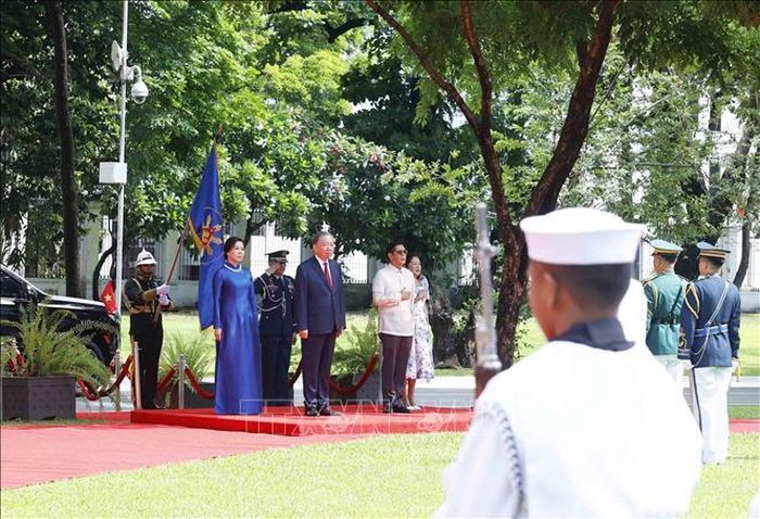 Tổng Bí thư, Chủ tịch nước Tô Lâm và Phu nhân cùng Tổng thống Philippines Ferdinand Romualdez Marcos Jr. và Phu nhân trên bục danh dự, nghe Quân nhạc cử Quốc thiều hai nước. Ảnh: Thống Nhất/TTXVN