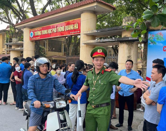 Hướng dẫn phụ huynh dừng chờ đón con em. Ảnh: Thùy Vân
