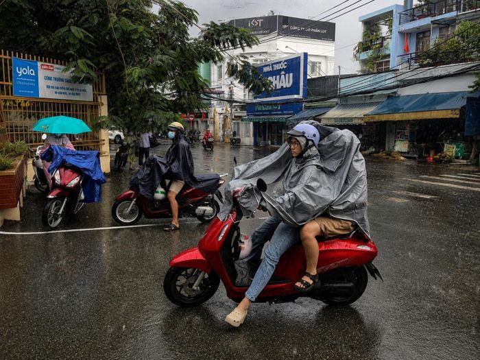 Cơn mưa bất chợt khiến các phụ huynh và học sinh phải đội mưa đến điểm thi môn Ngoại ngữ.