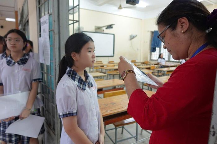 Giám thị kiểm tra thông tin và giấy báo thi của thí sinh trước khi vào phòng thi.