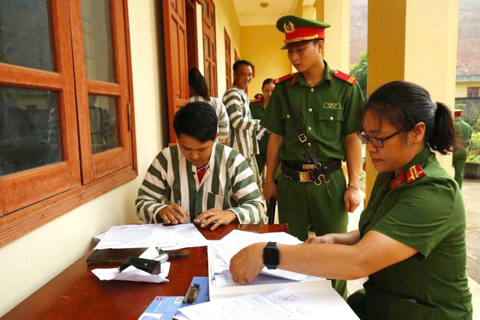 Cán bộ Trại tạm giam số 2 Công an tỉnh Tuyên Quang kiểm tra, hướng dẫn phạm nhân hoàn thiện các thủ tục trước khi trở về địa phương sau khi được đặc xá. Ảnh: Minh Tâm/TTXVN