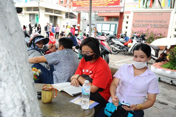 Một số phụ huynh chọn đọc sách, lượt mạng trong lúc chờ con làm bài thi.