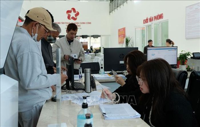 Cán bộ Trung tâm phục vụ hành chính công tỉnh Lâm Đồng hướng dẫn người dân đến làm thủ tục hành chính tại đơn vị. Ảnh: Nguyễn Dũng/TTXVN