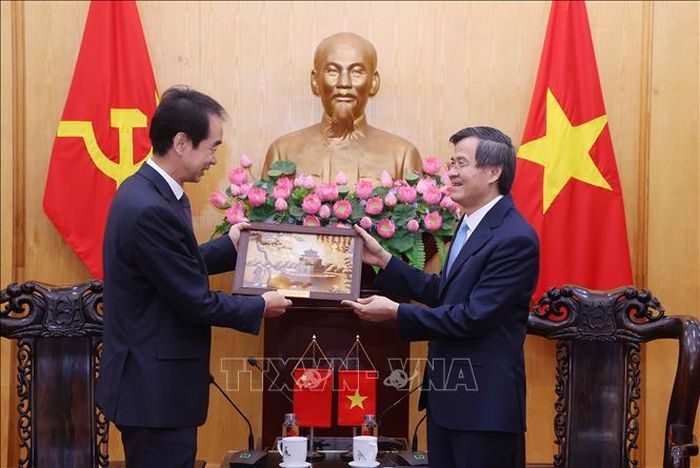 Đồng chí Đoàn Minh Huấn, Giám đốc Học viện Chính trị quốc gia Hồ Chí Minh tặng quà lưu niệm đồng chí Hà Vĩ, Đại sứ Đặc mệnh toàn quyền nước Cộng hòa Nhân dân Trung Hoa tại Việt Nam. Ảnh: Văn Điệp/TTXVN