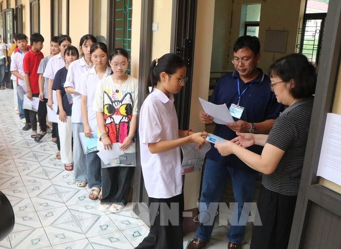 Giám thị gọi tên thí sinh vào phòng thi. Ảnh: Thu Hương – TTXVN