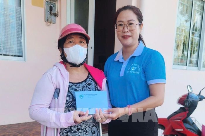 Bà Võ Thị Hồng Dung, Chủ tịch Hội Liên hiệp Phụ nữ xã Cầu Ngang trao tiền hỗ trợ phụ nữ có hoàn cảnh khó khăn từ nguồn bán vé số gây quỹ. Ảnh: TTXVN phát