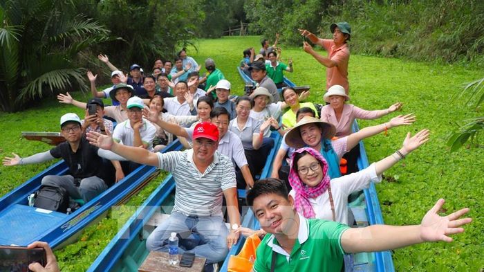 Du khách tham quan Khu du lịch sinh thái Mùa Xuân bằng ghe. Ảnh: Nguyễn Hằng - TTXVN