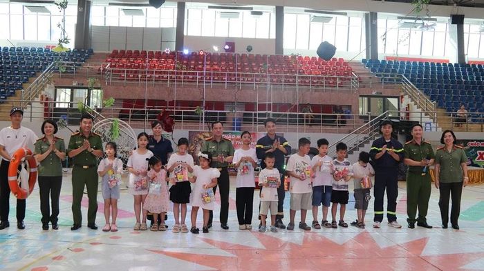 Đại tá Trần Thái Quang Hoàng, Phó Giám đốc Công an tỉnh và các đồng chí lãnh đạo phòng, ban Công an tỉnh tặng quà cho các diễn viên nhí tham gia truyền thông
