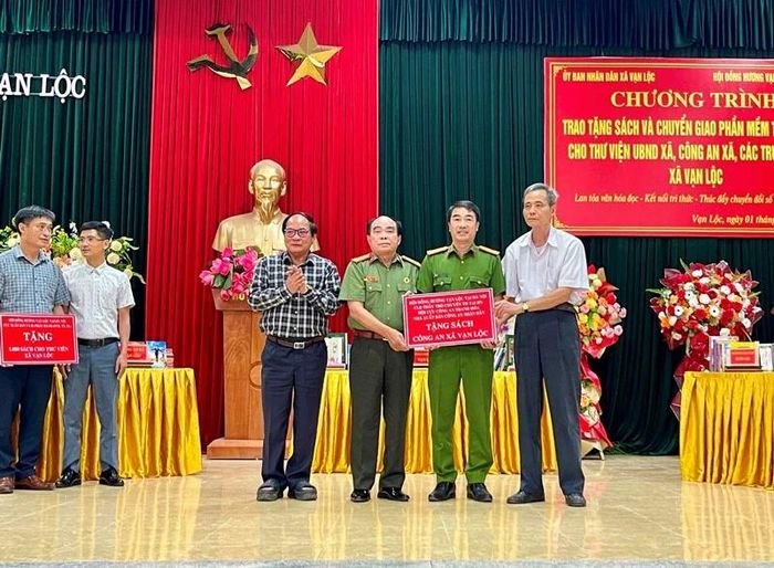 Đại diện các tổ chức trao biểu trưng tặng sách cho Công an xã Vạn Lộc.