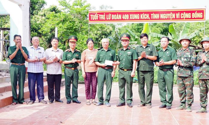  Đại tá Đào Văn Chung, Lữ đoàn trưởng Lữ đoàn 409 trao quà cho gia đình thương binh Nguyễn Văn Hùng. 