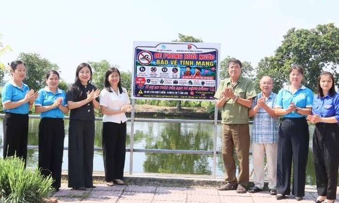  Các đại biểu thực hiện gắn biển cảnh báo phòng chống đuối nước tại thôn Nội Viên (xã Tân Chi). 