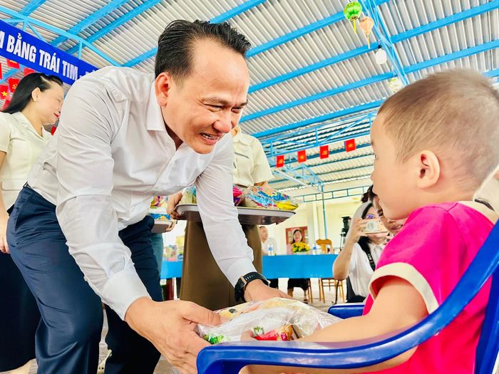 Phó Bí thư Thường trực Thành ủy Nguyễn Đình Vĩnh trao quà cho trẻ em Làng Hòa Bình Quảng Nam. Ảnh: ALĂNG NGƯỚC