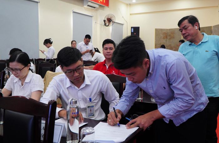 Đại diện tổ chức, cá nhân trúng đấu giá ký biên bản tại buổi xét duyệt hồ sơ. Ảnh: TÂM ĐAN