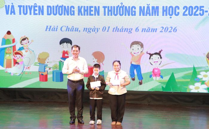 Đại diện lãnh đạo phường Hải Châu trao 2 suất quà của Sở Y tế cho học sinh vượt khó vươn lên trong học tập. Ảnh: ĐẮC MẠNH