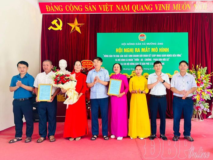Lãnh đạo xã Mường Ảng tặng hoa chúc mừng đại diện 2 mô hình tại lễ ra mắt.