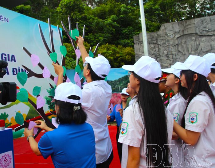 Học sinh, sinh viên gắn những chiếc lá mang thông điệp yêu thương lên mô hình “Cây yêu thương”.