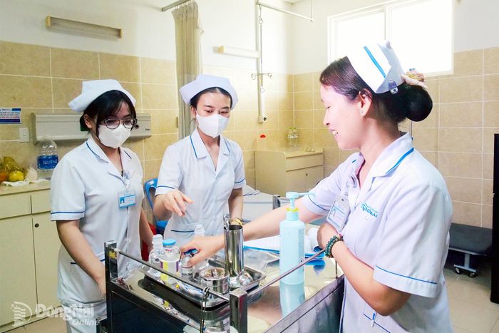 Điều dưỡng Trần Thị Minh Ngọc (phải), Khoa Dịch vụ tổng hợp Bệnh viện Đa khoa Đồng Nai hướng dẫn các điều dưỡng trẻ thực hiện chuyên môn. Ảnh: An Yên