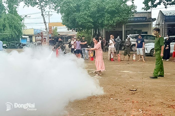 Lực lượng PCCC cơ sở và người dân tự tin thực hành dập tắt đám cháy bằng phương tiện cầm tay dưới sự giám sát an toàn. Ảnh: PV