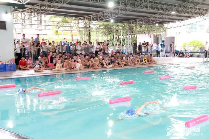 Các em thiếu nhi được xem các vận động viên bơi lội biểu diễn các kiểu bơi. Ảnh: Nga Sơn