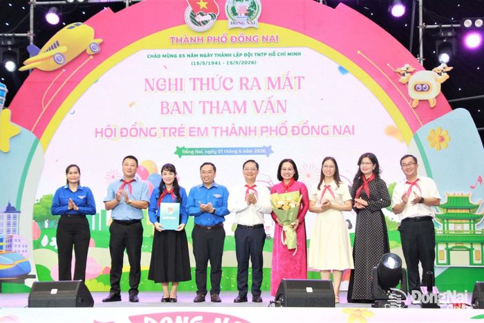 Các đại biểu trao quyết định và tặng hoa Ban Tham vấn Hội đồng trẻ em thành phố. Ảnh: Nga Sơn