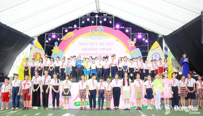 Các đại biểu trao quyết định và tặng hoa Hội đồng trẻ em thành phố. Ảnh: Nga Sơn