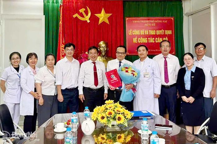 Bác sĩ chuyên khoa II Lê Quang Trung, Phó Giám đốc Sở Y tế trao quyết định cho ông Đỗ Minh Quang. Ảnh: CTV