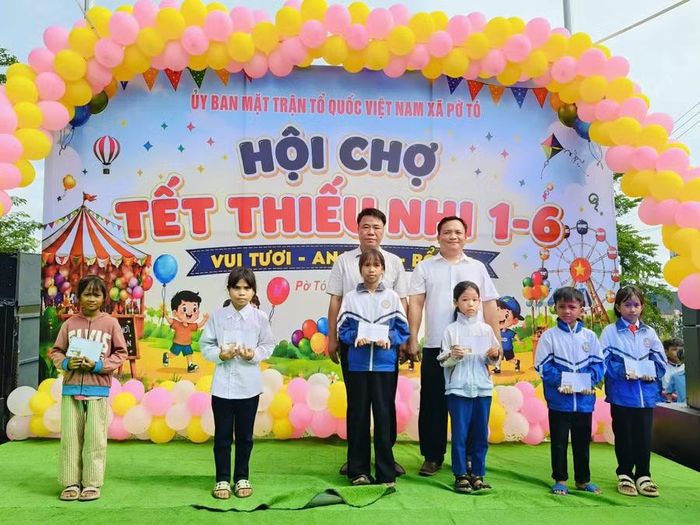 Lãnh đạo xã và đơn vị tài trợ tặng quà cho các em học sinh nghèo vượt khó học giỏi tại chương trình. Ảnh: Như Loan