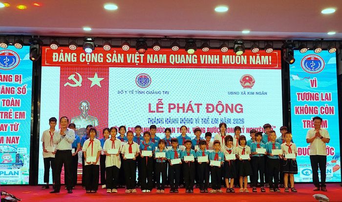 Đồng chí Đào Mạnh Hùng, Phó Chủ tịch Thường trực Ủy ban MTTQ Việt Nam tỉnh và lãnh đạo xã Kim Ngân trao quà cho các em học sinh tại lễ phát động - Ảnh: Q.N