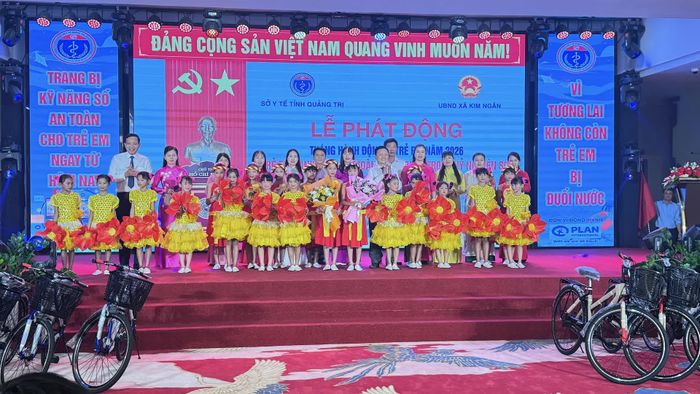 Ban Tổ chức tặng hoa chúc mừng các tiết mục văn nghệ của các em học sinh tại lễ phát động - Ảnh: Q.N.