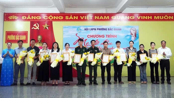 Lãnh đạo Ủy ban MTTQ Việt Nam phường tặng hoa cho các tổ chức, cá nhân hảo tâm đồng hành cùng chương trình “Mẹ đỡ đầu” - Ảnh: N.M