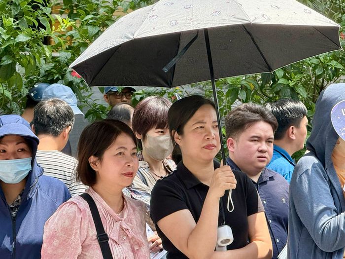 Phụ huynh đứng chờ bên ngoài điểm thi trong tâm trạng hồi hộp.