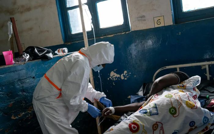 Nhân viên y tế đang điều trị cho một bệnh nhân trong khu điều trị Ebola. Ảnh: The New York Times