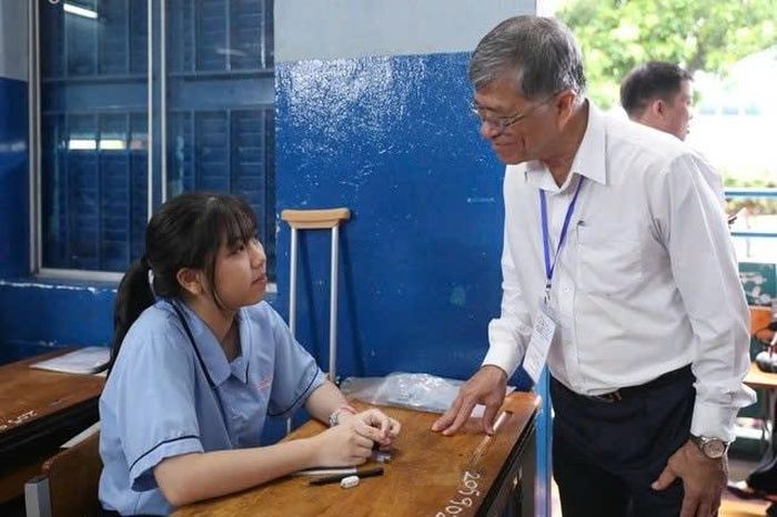 Giám đốc Sở GD-ĐT TP. Hồ Chí Minh Nguyễn Văn Hiếu động viên tinh thần nữ sinh vì phải chống nạng đi thi tại điểm thi Trường THCS Lê Lợi