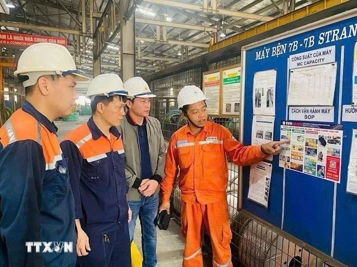 Công nhân (EVNHANOI) hướng dẫn khách hàng sử dụng điện an toàn, tiết kiệm. Ảnh: TTXVN