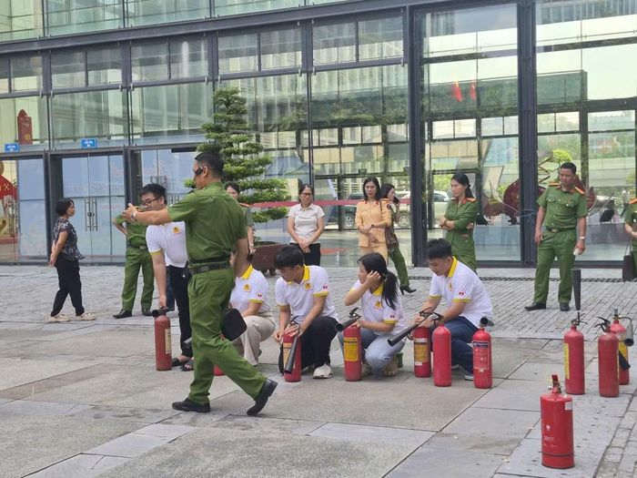 Các cán bộ Cảnh sát PCCC hướng dẫn các cháu học sinh thực hành kỹ năng sử dụng bình chữa cháy.