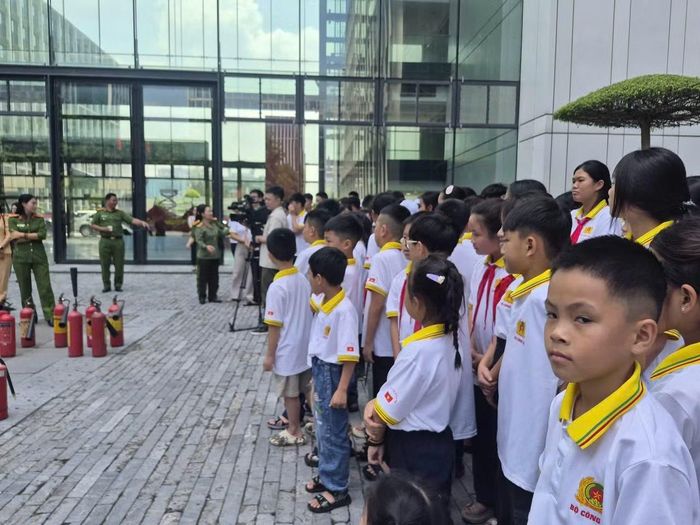 Các em nhỏ vui vẻ khi đứng theo dõi các anh chị lớn hơn thực hành kỹ năng chữa cháy.
