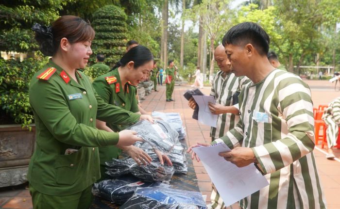 Cán bộ Trại giam Phú Sơn 4 trao quần áo cho các phạm nhân được đặc xá.