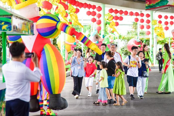 Từng dòng người rộn ràng nối đuôi nhau di chuyển qua những cổng chào tiến vào khu vực bên trong.